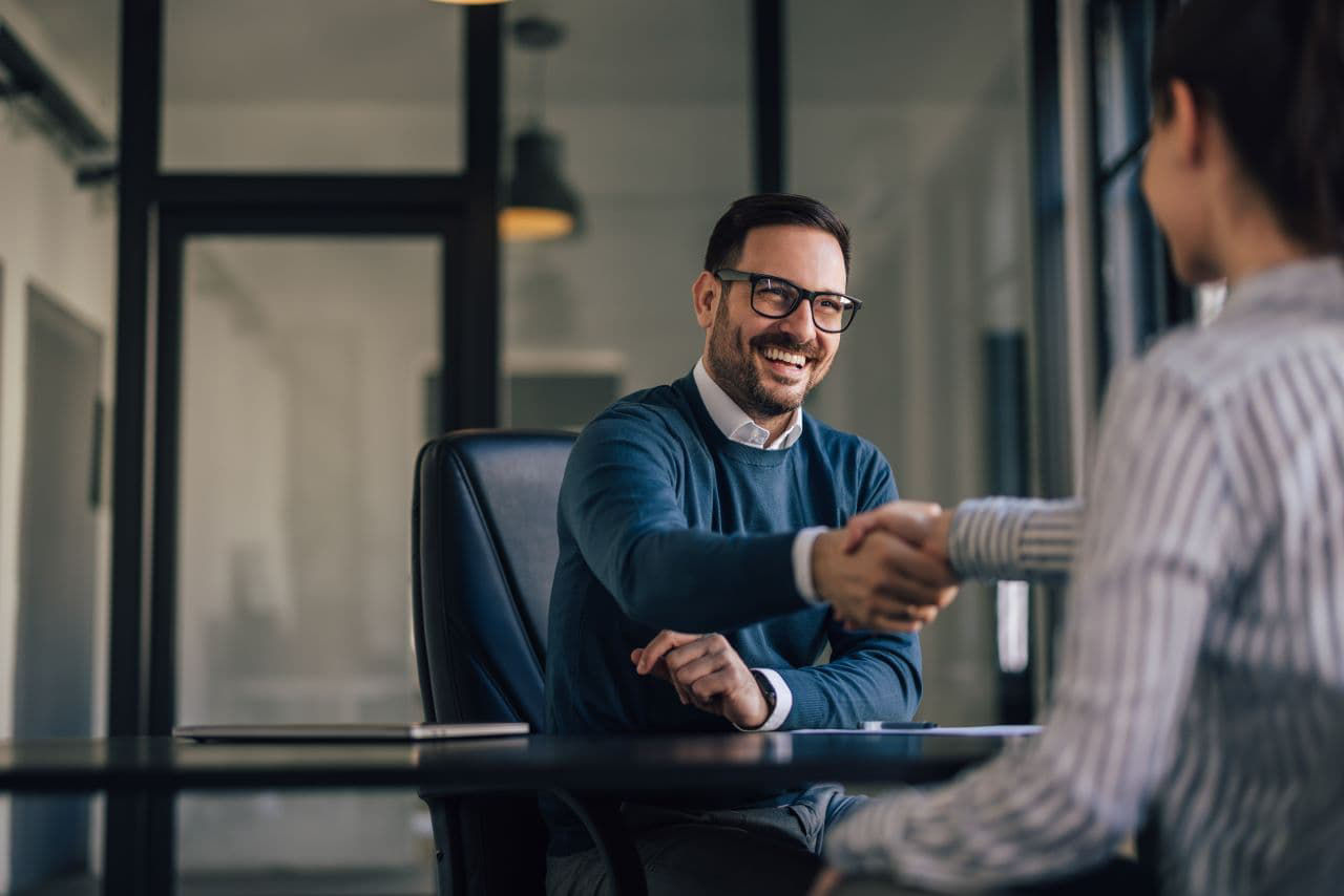 Happy man with glasses on just made a deal with another company owner.