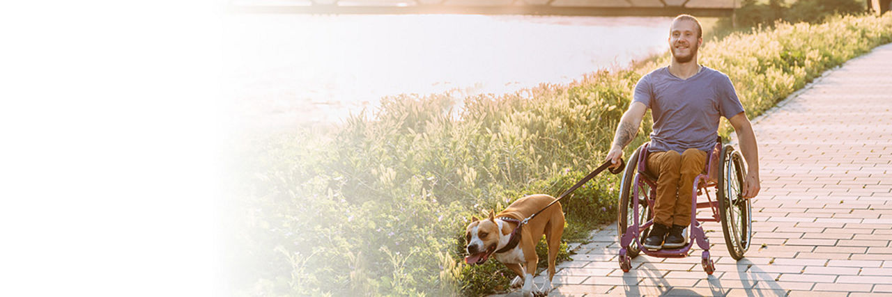 A photo of a man in a wheelchair with his dog