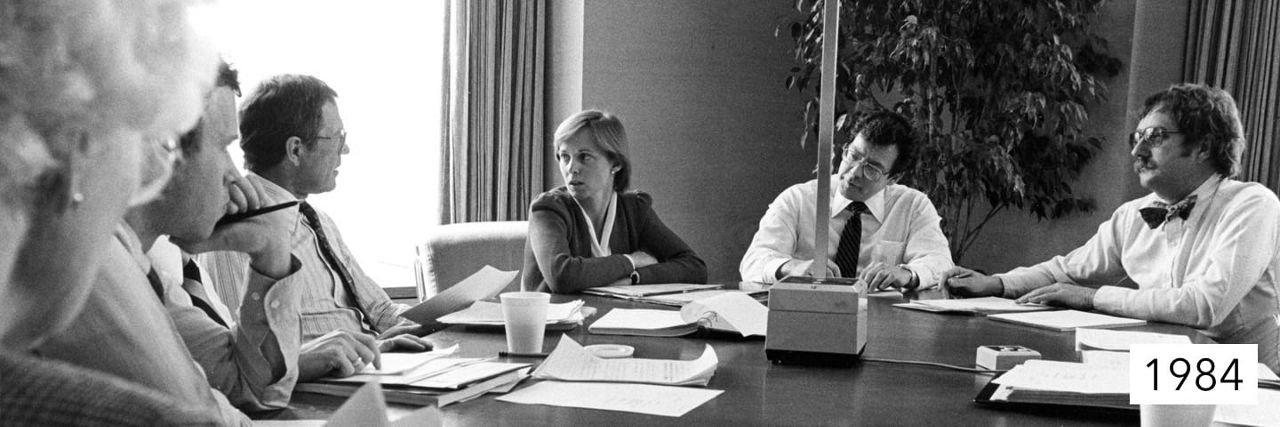 Photo from 1984 of Capital Group associates sitting around a table.