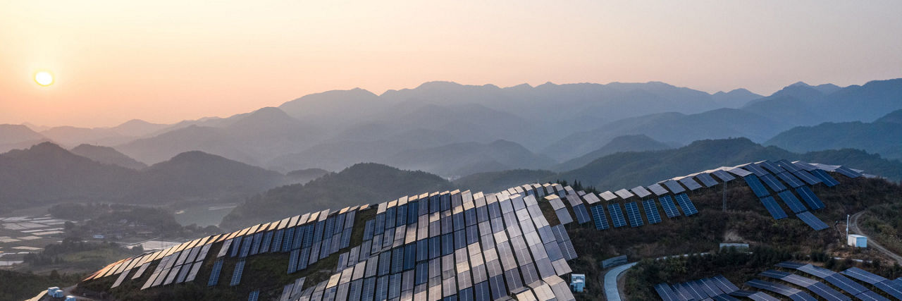 Aerial view of the solar power plant on the top of the mountain at sunset